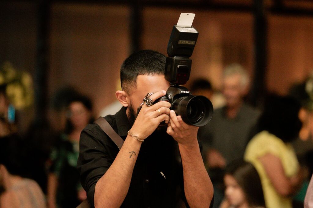 A photographer captures moments at an indoor event in Alpinópolis, Brazil.